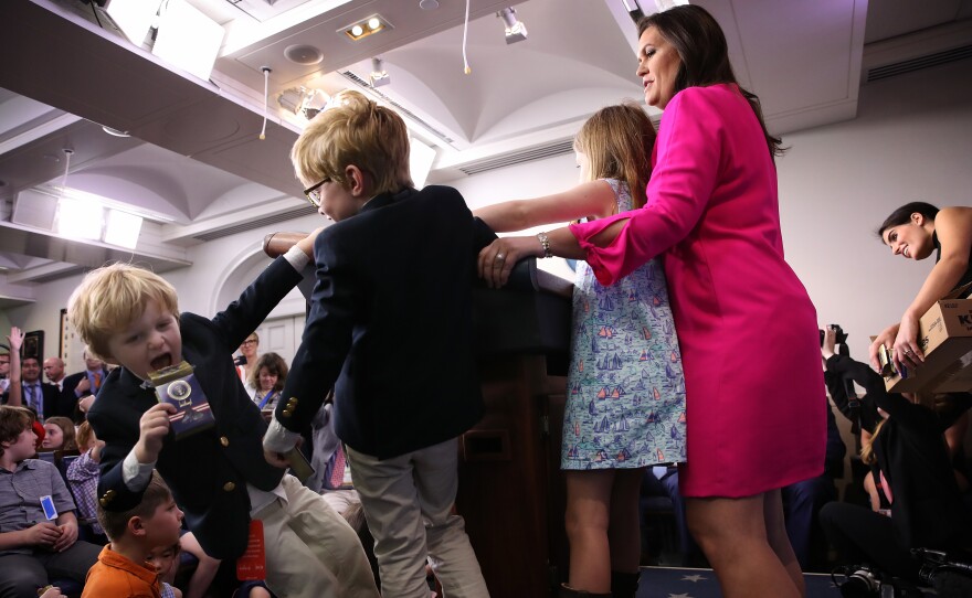 As her children stay close by, White House press secretary Sarah Huckabee Sanders answers questions from children of White House staff and reporters on April 25, 2019 in Washington, DC. Sanders held the briefing as the U.S. celebrated "Bring Your Son and Daughter to Work Day".