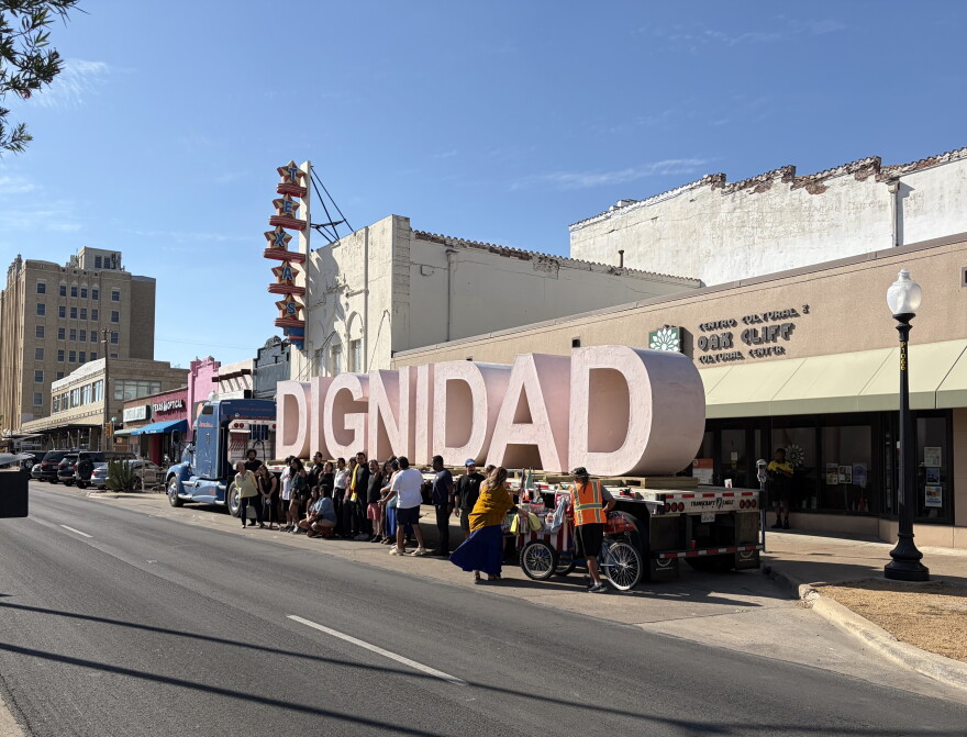 People pose with the sculpture "Dignidad" on Jefferson Boulevard in Oak Cliff.