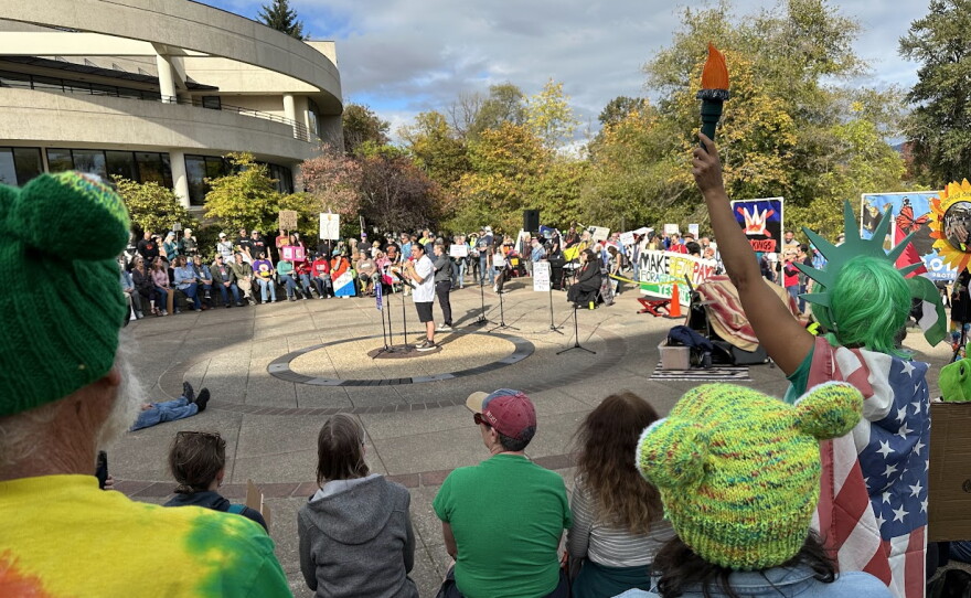 People listening to speaker in outdoor venue. 