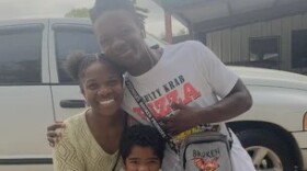 A mom, a teenage son and a young child pose for a family photo.
