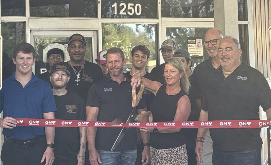 Staff pose during a ribbon cutting at Piesanos Stone Fired Pizza on West University Avenue in Gainesville on March 30, 2026. (???????/WUFT News)