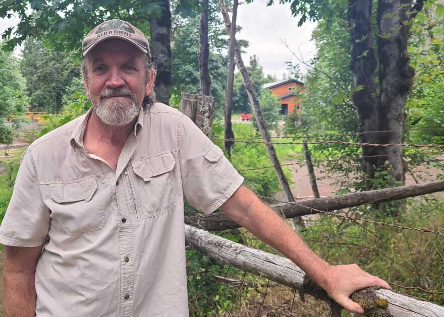 Mark Shaffer stands at the edge of his property in this June 25, 2026 photo. One of the unpermitted structures on Kathleen Jones-McCann in the background.