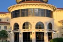 A cream colored rotunda by a gray brick sidewalk
