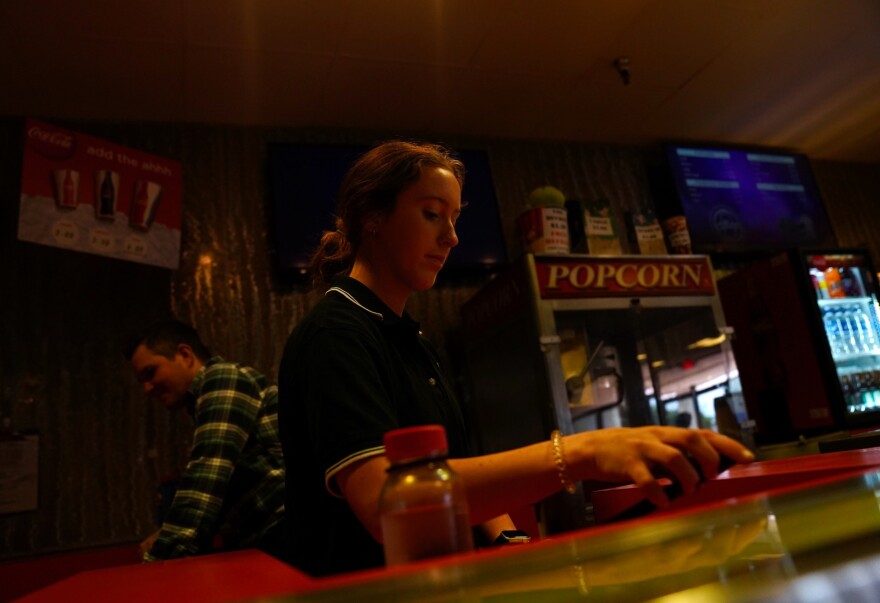 Liz, a Village 8 employee, works the concessions stand on June 11, 2022, one of the discount movie theater's final weekends.