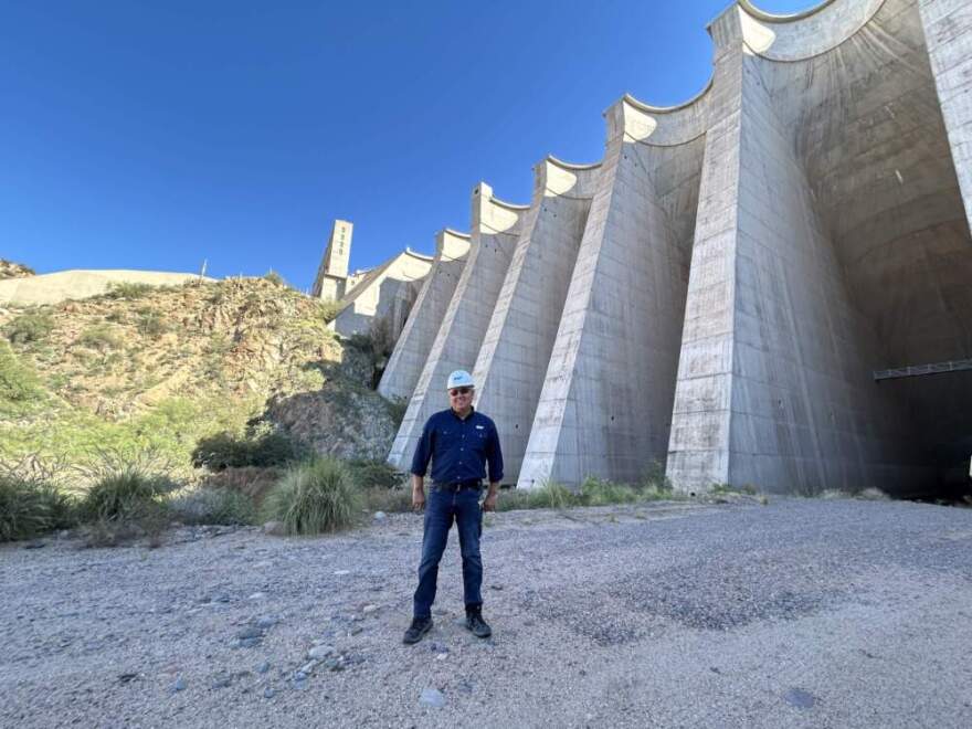 Don McMillan stands next to the concrete structure of the dam. (Peter O'Dowd/Here & Now)