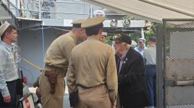World War II veteran Army SSgt. John Long, in blue jacket, talks with WWII reenactors Daniel Morgan, left in brown, and Lukas Smith at Buffalo and Erie County Naval and Military Park.
