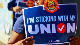 A person carrying a sign that says "I'm sticking with my union, AFL-CIO." Seven in 10 Americans said they support unions, but only one in 10 is a member.