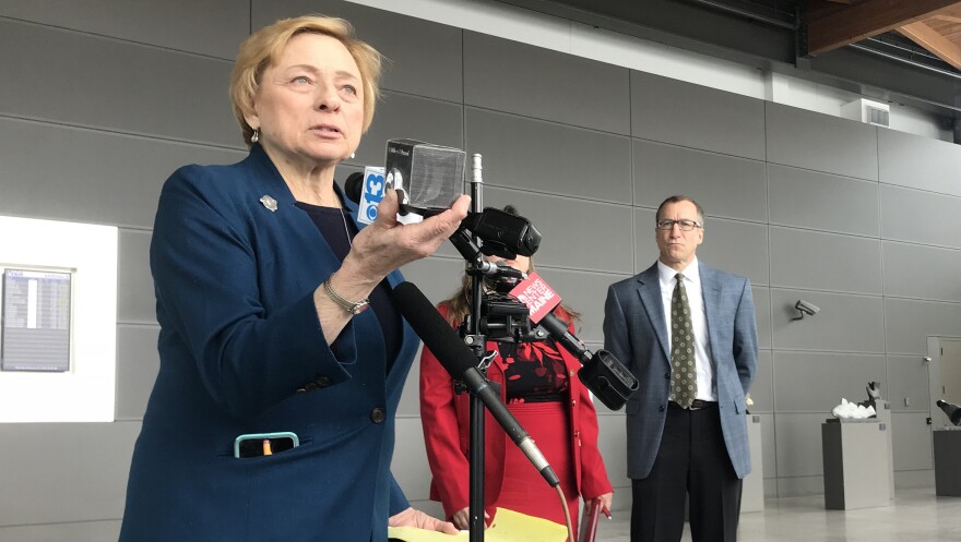 Gov. Janet Mills holds up a pound of carbon at a press conference at the Portland Jetport on Thursday.