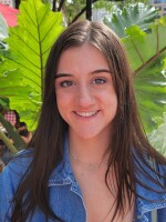 Female wearing a denim jacket in front of a green background