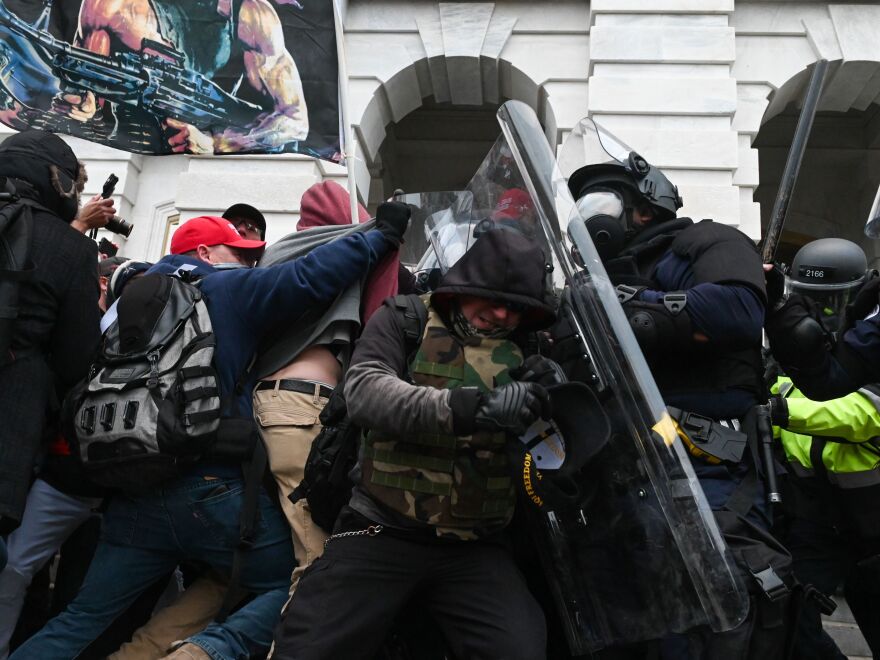 Riot police push back a crowd of Trump supporters after they storm the Capitol.