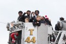 Two Manual High School basketball players show off their medals on the top of a firetruck.