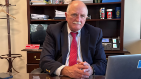 Stern man with mustache at desk