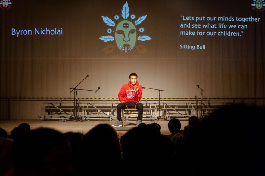 Toksook Bay singer and drummer Byron Nicolai performs on the Cama-i stage beneath the image of Auluturta, designed by Sivaluaq Jerry "Bucket" Lieb, at Bethel Regional High School on March 29, 2019.