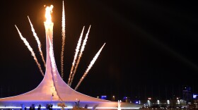 Fireworks explode behind the Olympic flame cauldron, announcing the official opening of the Winter Olympics in in Sochi, Russia.