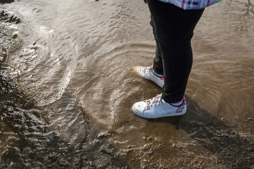 A young girl wades in the shallow water on the shore of the Anacostia River. She visited Seafarers to participate in the 2013 Earth Day Clean Up.