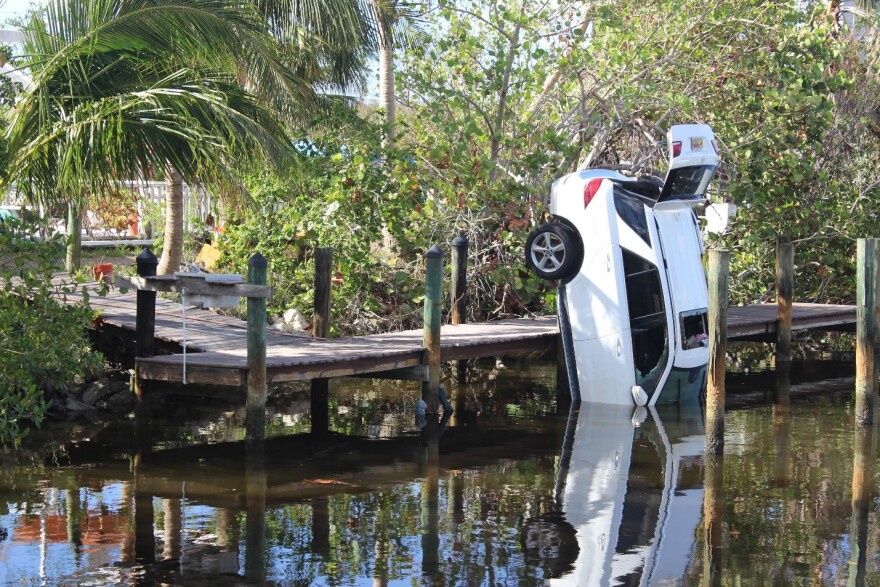 A neighbor’s car was swept into the canal behind Chase Hussey and Erica Racz’s Fort Myers Beach home.