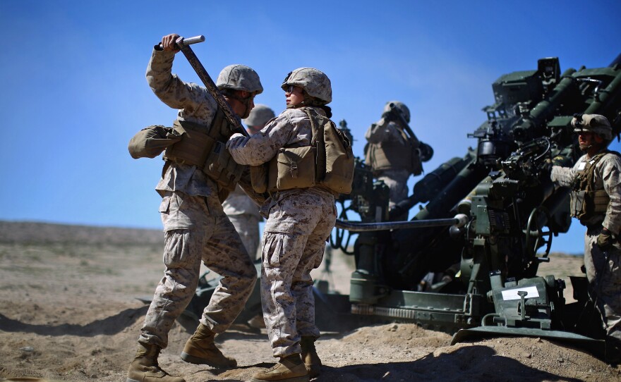 Carolina Ortiz moves away from a 155 mm artillery piece after loading it during a live-fire exercise at the Marine base in Twentynine Palms, Calif. The Marine Corps is trying to determine whether women can serve in ground combat jobs: artillery, armor and infantry. Alpha Company is undergoing training in the Mojave as part of a months-long experiment to figure that out.