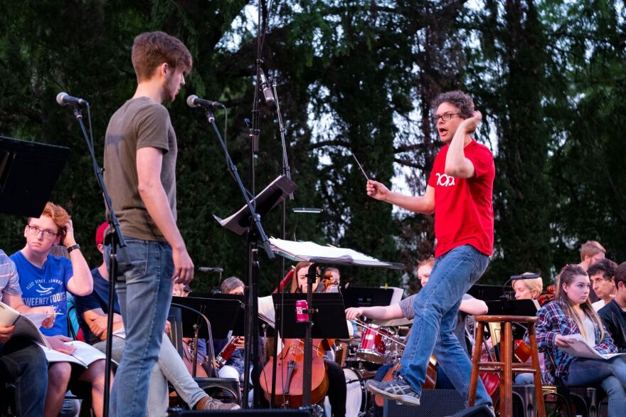 photo of Zach Meeker and Jim Waddelow in front of an orchestra