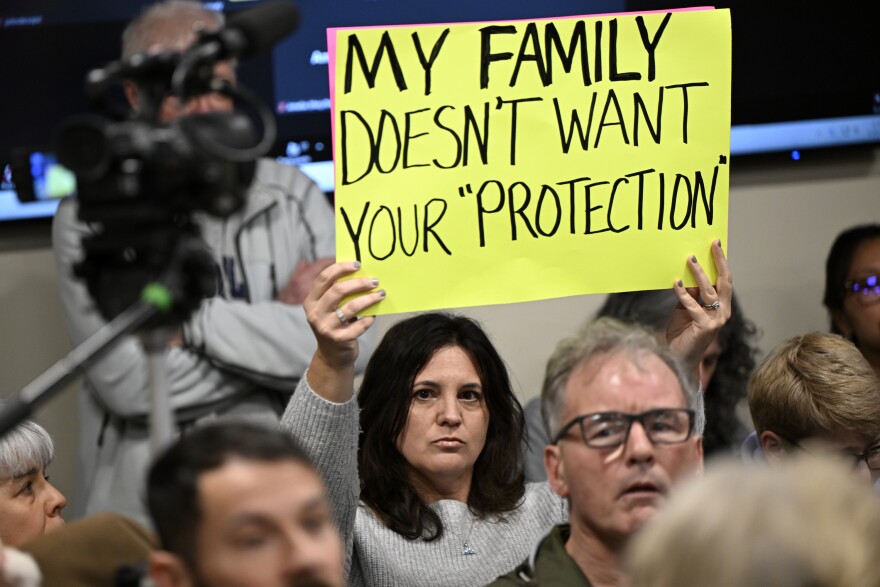 Kristen Hamilton of Suffield raises her sigh as word spreads the Kent Memorial library commission may cancel their public meeting that was to vote on library policy, "youth collection acquisition and retention policy presentation & discussion” at the town hall in Suffield, ϳԹ March 20, 2025.