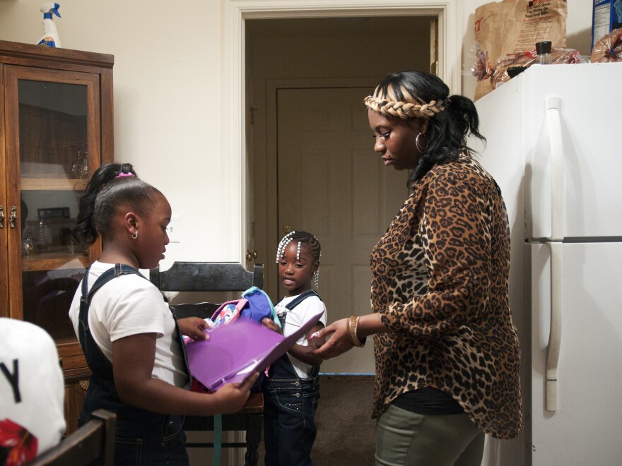 Rachel Jenkins welcomes her daughters Kyonna Jenkins (left) and Ti'yonna Hill home from school in Boley, Okla. Rachel injured her shoulder while working as a nursing assistant and was originally denied benefits because she reported the incident three hours too late.