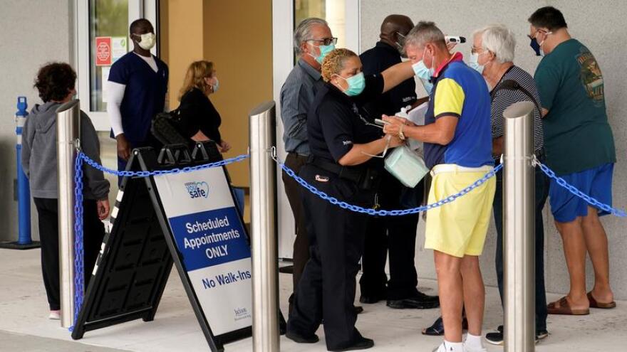 File photo of people waiting in line to receive the Pfizer-BioNTech COVID-19 vaccine.