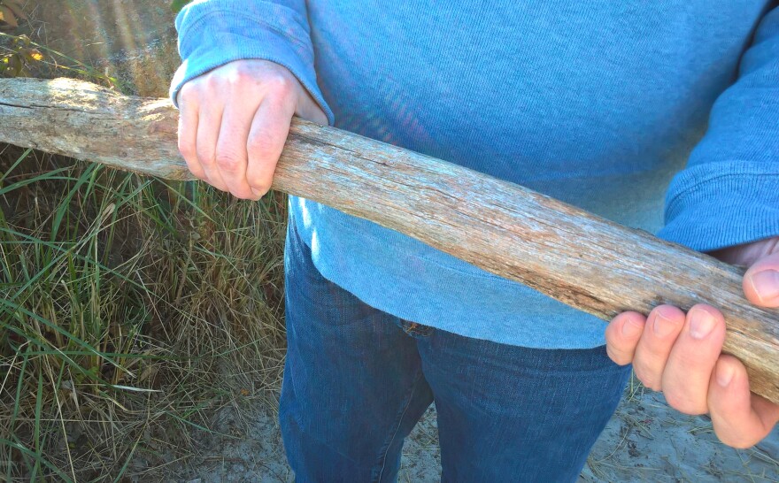 Steve Spofford holds a piece of wood he found that he believes is a remnant from the 1947 fires in Maine.