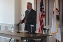 Congressman Eric Sorensen hosts a town hall in Peoria Ill. Stands in front of three flags. American Illinois and Peoria. 