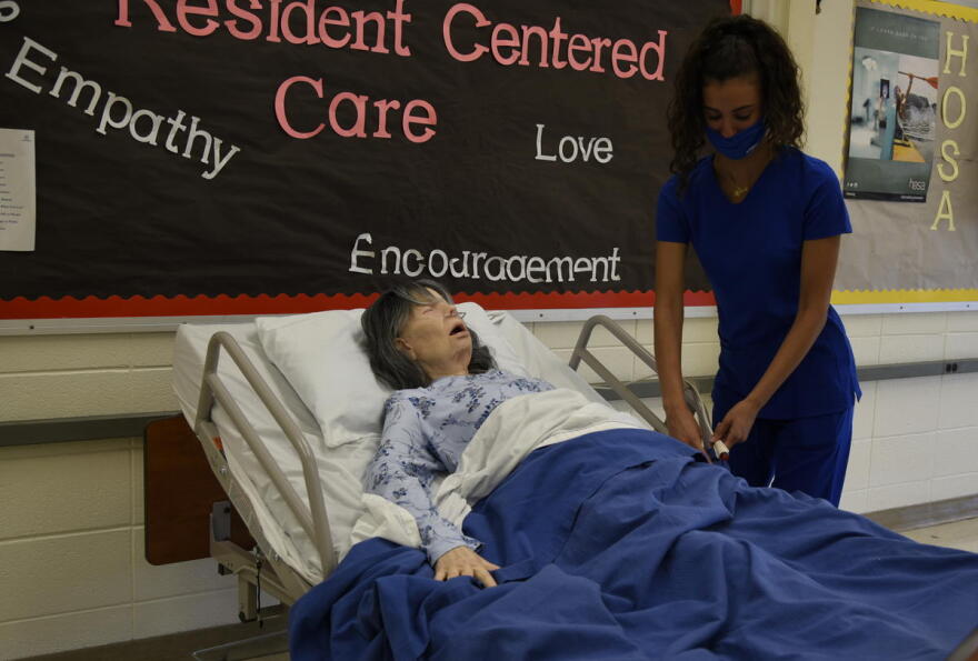 Andrea Zaknoun, a CTE student at A.K. Smith Career Center studying to become a certified nursing assistant, practices on a mannequin in a classroom during a Summer Bridge program. (Justin Hicks/IPB News)