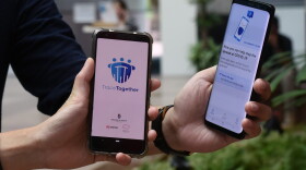 Government Technology Agency (GovTech) staff demonstrate Singapore's new contact-tracing smarthphone app called TraceTogether, as a preventive measure against the COVID-19 coronavirus in Singapore on March 20, 2020. (CATHERINE LAI/AFP via Getty Images)