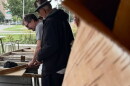 Ron J. Paquin framed by birch looking over the canoe build