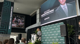 A man speaks into a microphone at a podium