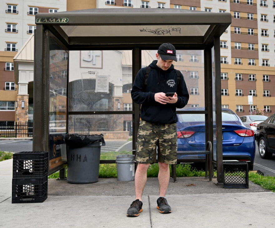 Nathan Lund, 30, a Harrisburg resident, waits for the bus on April 13, 2022. He takes a Capital Area Transit bus from N. 6th and Calder streets to the Amazon fulfillment center in Carlisle where he works. 