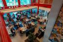 Tables and chairs filled with adults listening to a lecture.