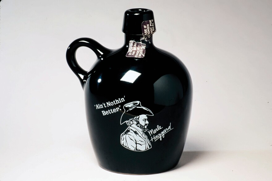 To honor its long-serving brand ambassador, Dickel sold this jug featuring country music star Merle Haggard in the 1970s and early 1980s. From <em>The Art of American Whiskey</em> by Noah Rothbaum.