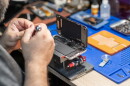 A skilled technician performs phone repair and replaces a battery.