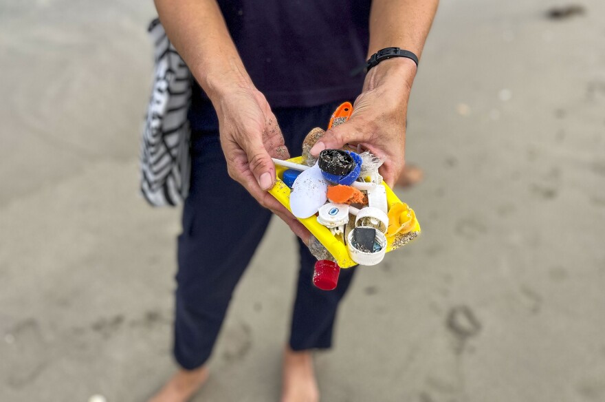 Catherine Uden shows some of the plastic bits and trash she finds on her paddleboard outings.