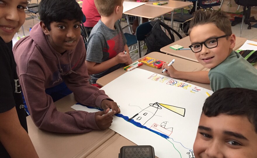 Students in Leslie Nielsen's class at Community House Middle School in Charlotte work on posters seeking gift cards for Ocracoke School, which was damaged during Hurricane Dorian.