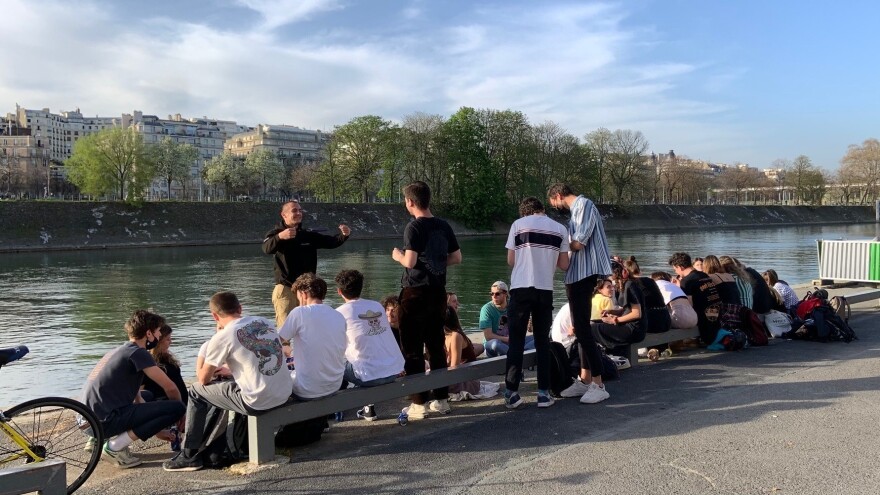 Young people gathered Wednesday by the Seine River in Paris, largely without masks and without social distancing. French President Emmanuel Macron has ordered the country into a third lockdown because of the continued spread of COVID-19.