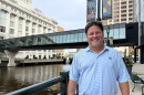 Retired Nicolet High School social studies teacher Mark Schill in front of the Milwaukee River in downtown Milwaukee, Wisconsin. 