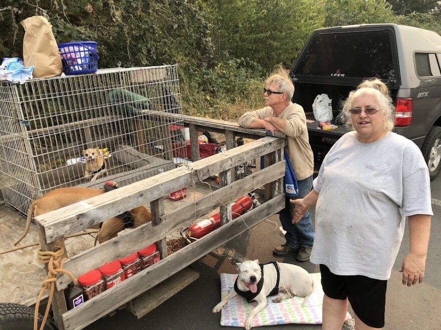 Trudy Hammond (right) and Terry Casado (left of Hammond) of Oakridge, with their rescue dogs, including Scrappy, Vixen, Cosmos, Jessie, and Thor, were evacuated during the 2022 Cedar Creek Fire.