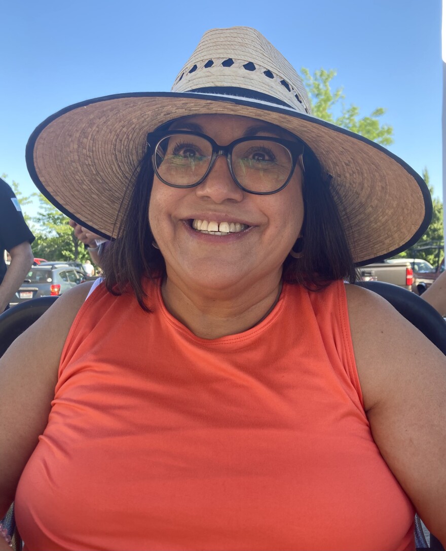 Portrait of Raquel Sequel wearing a straw hat, outdoors, smiling 