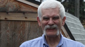 white-haired man with blue shirt smiles
