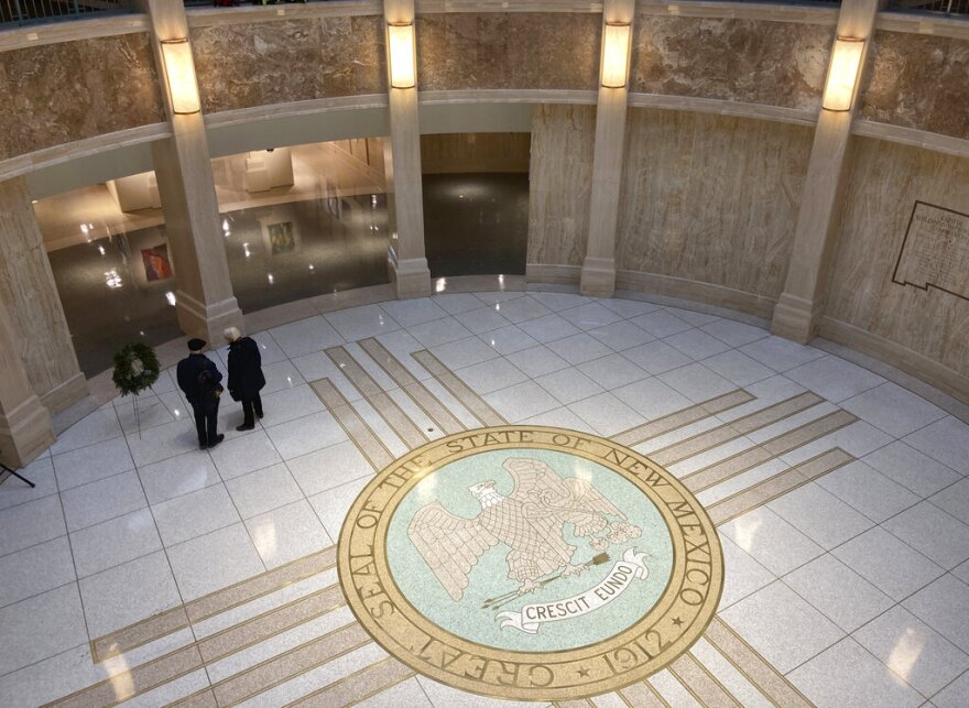 Visitors stroll through the New Mexico state Capitol building in Santa Fe, N.M., on Monday, Dec. 12, 2022. State legislators are anticipating a multibillion-dollar financial windfall largely from surging oil production and robust energy prices in the era of war between Ukraine and Russia. Lawmakers will meet in January 2023 to craft a spending plan for the coming fiscal year. (AP Photo/Morgan Lee)