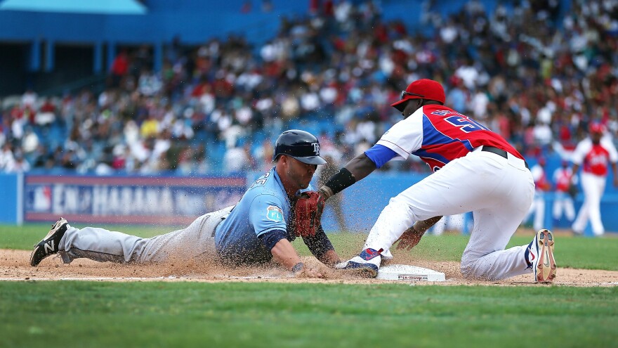 Tampa Bay Rays' Steve Pearce dives safely into third base during an exhibition game between the Cuban national team and the Tampa Bay Rays at the Estado Latinoamericano March 22, 2016 in Havana, Cuba.