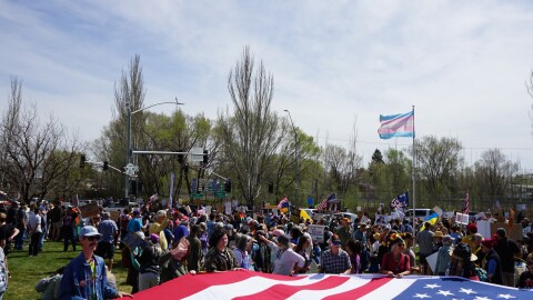 Protesters display a large American flag during a No Kings protest opposing the Trump administration in Flagstaff Sat, March 28.