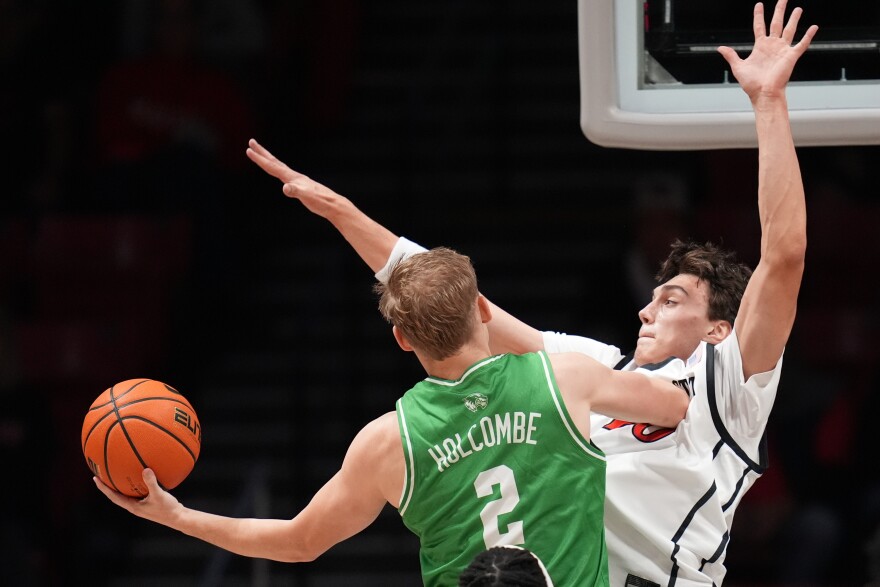 FILE - Utah Valley guard Jackson Holcombe (2) shoots as San Diego State forward Miles Heide defends during the first half of an NCAA college basketball game, Dec. 3, 2025, in San Diego.