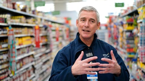 man stands in grocery store aisle.