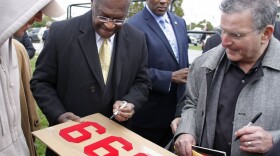 <p>On the day he revised his tax plan to 9-0-9, Republican presidential candidate Herman Cain signs a supporter's "999" sign after unveiling his "Opportunity Zone" economic plan in front of the Michigan Central Station, an abandoned train depot in Detroit.</p>