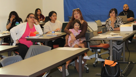 Daisy Ramos (center) holds her toddler during a tenant rights meeting on April 15, 2026. Policy advocates with Leadership Counsel For Justice and Accountability hosted the session to answer questions about the Merced City Council’s repeat housing code violators program ordinance.