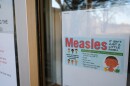 A sign in a window shares information about measles.